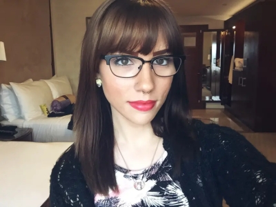 Beautiful girl with glasses seduces with her smile